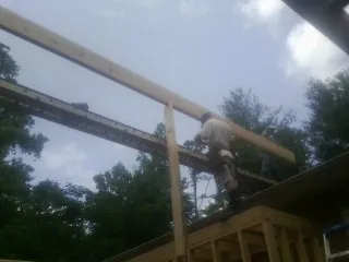 Carpenter setting a ridge beam over a new addition frame — Ice Dam Removal by Roofing Brothers in Sawyer