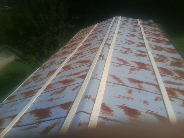 Rusted metal roof panels with new wood purlins before replacement — Storm Damage Roof Repair in Sawyer by Roofing Brothers