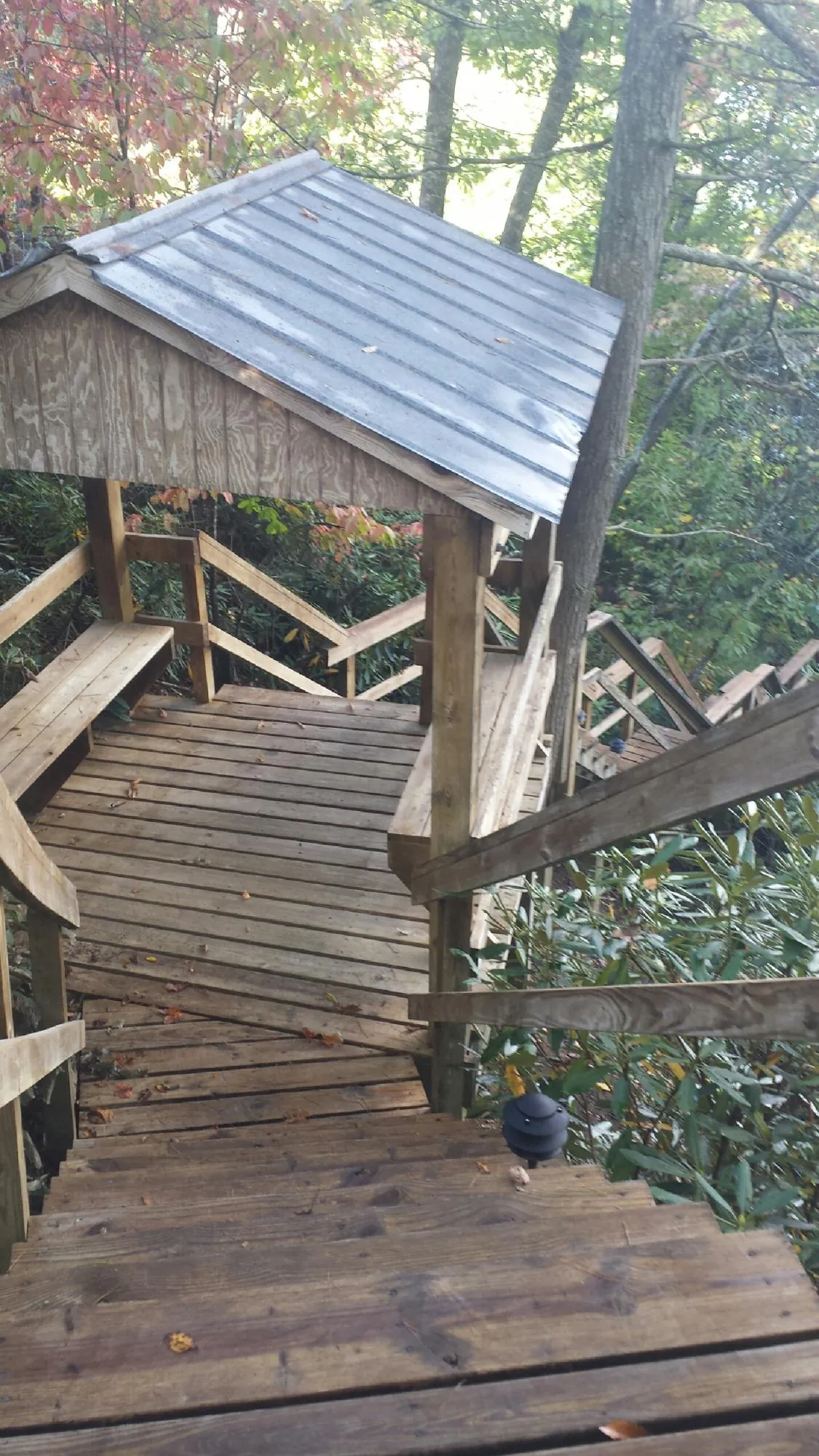 Metal roofed shelter over wooden steps on a wooded walkway — Skylight Repair & Installation work by our crew in Sawyer
