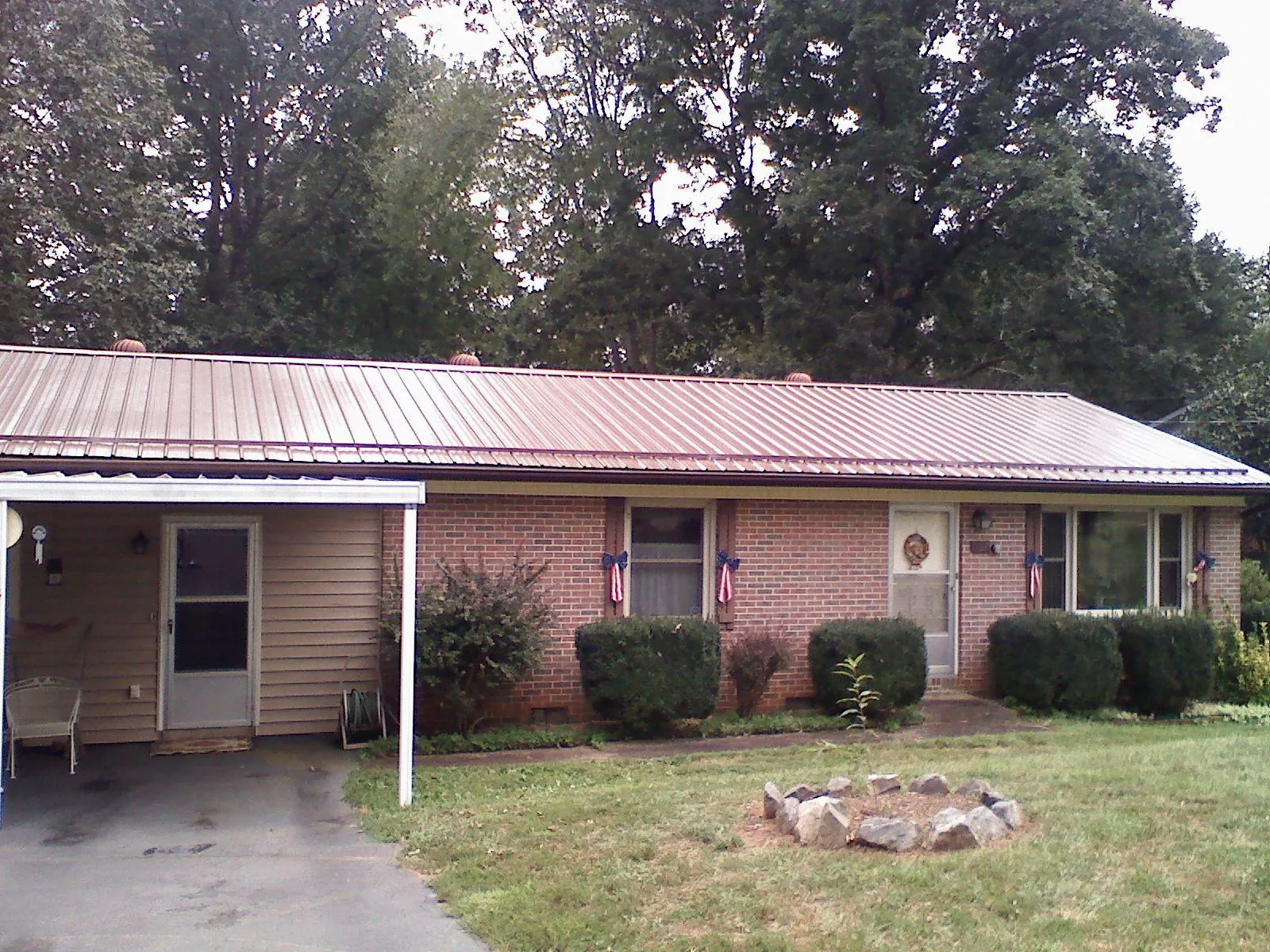 Bronze metal roof and carport on a brick ranch home — Roof Repair work by our crew in Sawyer